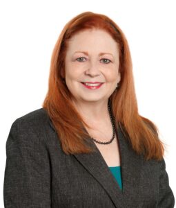 Lynn Maxwell, professional woman with red hair in business attire.