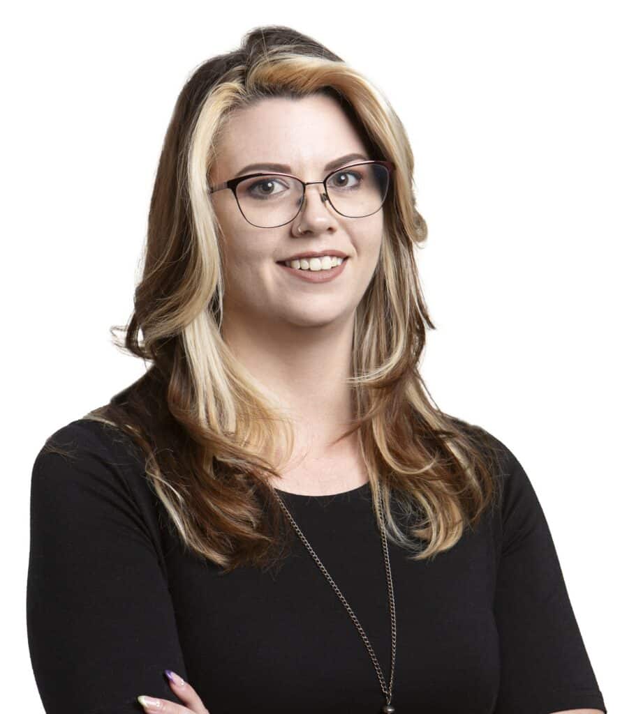 Portrait of Cait Miller with glasses and blonde hair for Corridor Title.