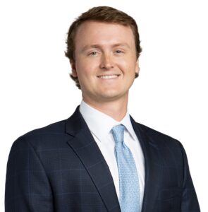 Cullen Lowder wearing a suit and tie, smiling for the camera.
