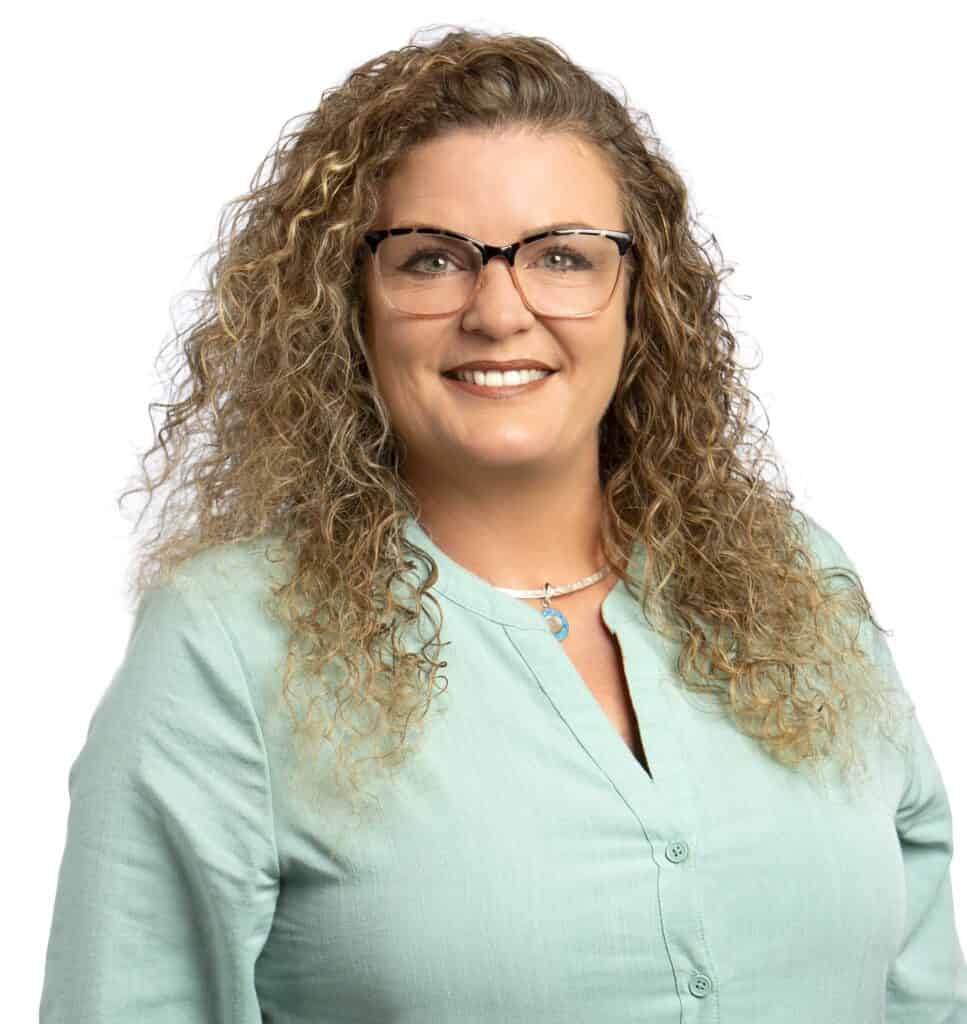 Joleen Escobar smiling with curly hair and glasses in a professional portrait.
