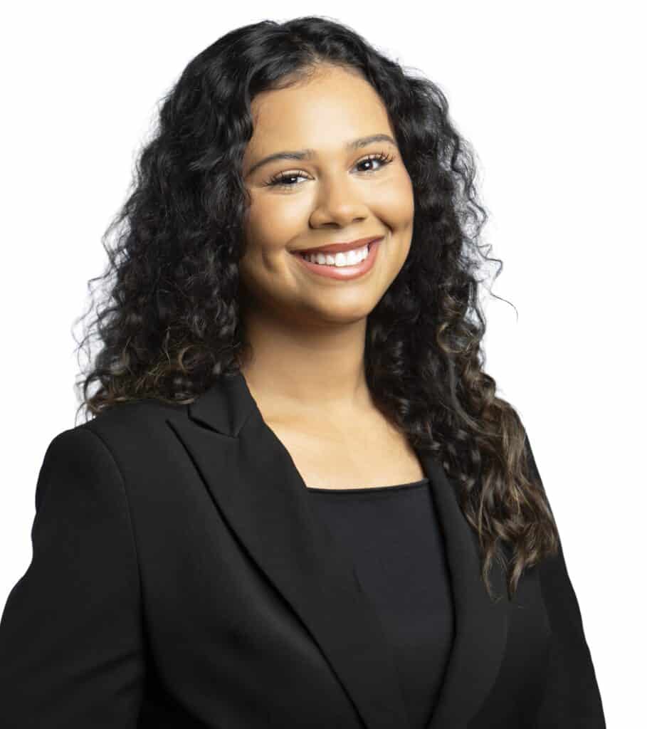 Portrait of a smiling woman with curly hair in professional attire.